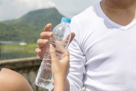 Hand Is Giving A Bottle Of Water To Man