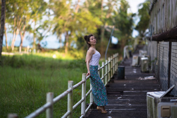 Fashionable girl of mixed race on an abandoned facility in the jungles of Asia.