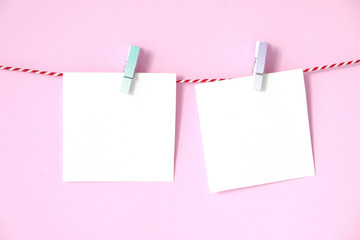 Blank white papers notepad hanging on pink background