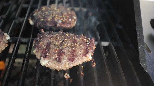 slider shot of hamburgers cooking on a grill