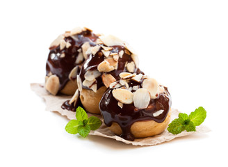 Homemade  chocolate profiteroles with almonds isolated on white