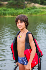 handsome boy in life jacket on the beach.