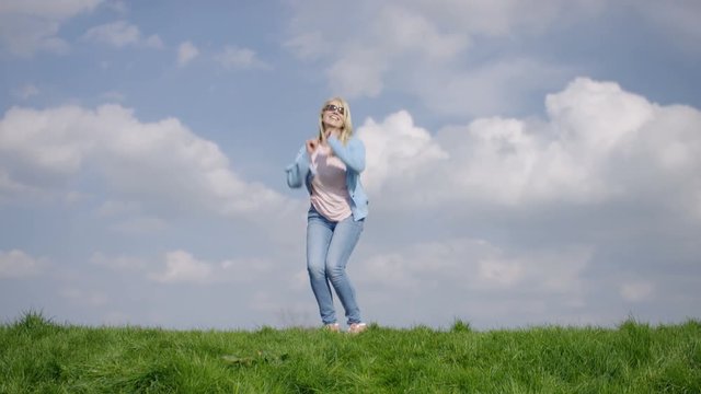 Mature woman having fun outdoors in the countryside, in slow motion