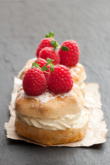 Traditional  scones with raspberry and cream on black stone background