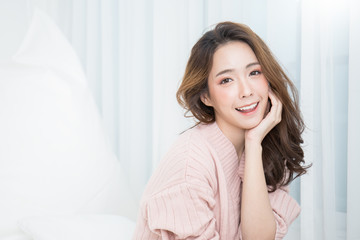 Portrait of young beautiful asian woman relax in her bedroom. Smile happy asian girl isolated on...