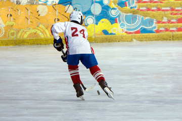 ice hockey player in action kicking with stick .