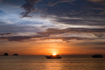 Fototapeta na wymiar A Beautiful sunset behind speedboat at the ocean