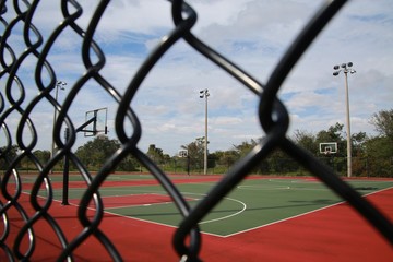 Empty Basketball Court with Hoops Seen Through Chain-Link Fence, Quiet Waters Park, Deerfield...
