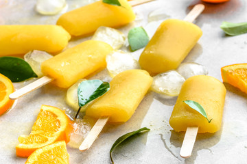 Orange popsicles with frozen juice and ice cubes, summer refreshing snack