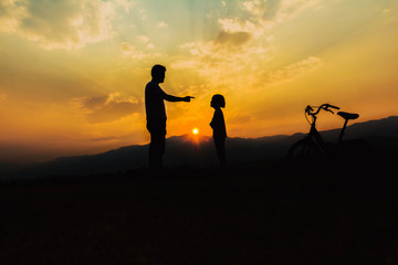 Fototapeta na wymiar Silhouette man and little girl at sunset time.Child abuse and bullying in the family.