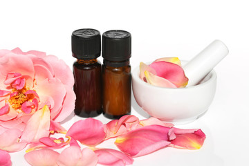 natural pure rose oil. essential rose oil set in brown glass bottles  and large pink rose on a white background. Organic Natural Oil