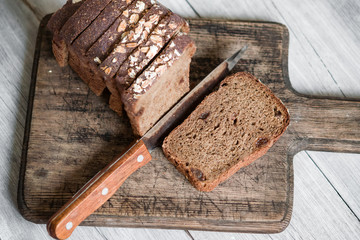 Pieces, slices of sliced rye sourdough bread with raisins on wooden Board, rustic background vintage, healthy natural food concept