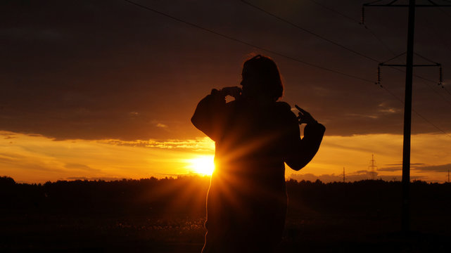 figure on a sunset background, sun and a man, a man in the dark, poses