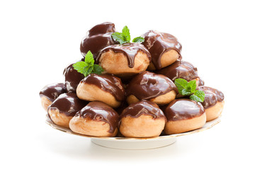 Homemade  profiterole choux with chocolate ganache on the plate isolated