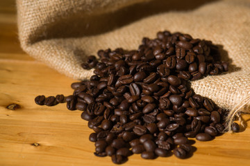 Fresh Roasted Coffee beans on wooden background.