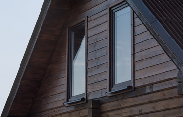 Mansard part with windows of the wooden house
