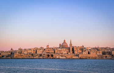 Fototapeta na wymiar Valletta skyline at Sunset, dominated by the dome of the Shrine of Our Lady of Mount Carmel, Malta.