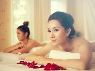 Obraz na płótnie Canvas Young Asian woman brunette skin relaxing in spa.young woman lying down on massage beds at Asian luxury spa and wellness center
