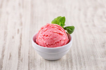 strawberry ice cream with bowl on wooden background