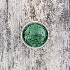 pistachio ice cream with bowl on wooden background