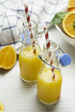 glass bottles with orange and straw.