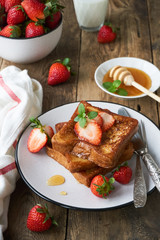 French toasts with honey and strawberries on a plate