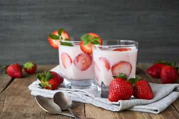 Strawberry yogurt in a glass on a wooden table       