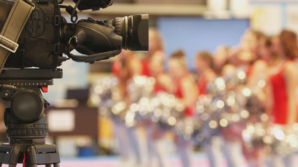 Camera in front of girls cheerleaders at sport championship