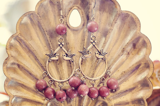 romantic earrings hanging on decorative background
