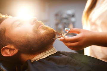 Young handsome bearded man visiting barber shop. Barber concept.