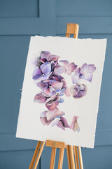 art class and speed painting courses. learn to draw with watercolors. tender purple flower picture on an easel