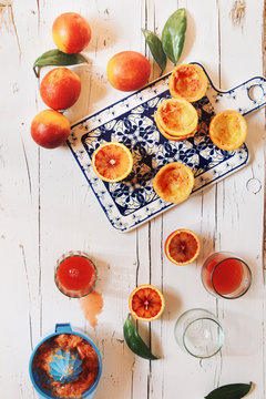 Preparing blood orange juice over white wooden table
