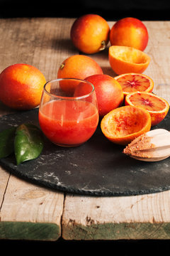 Preparing orange juice with manual squeezer in rustic table