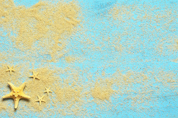 Summer sea background. Starfish and sand on a wooden blue background