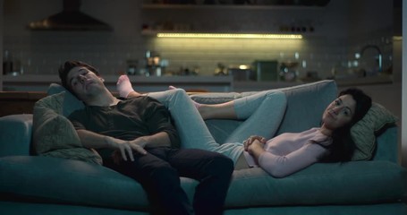 Man and woman slumped in front of the tv. - Powered by Adobe