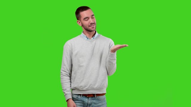 Confident guy presenting on green background