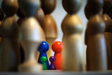 four colorful isolated little figures surrounded by large threatening blurry figures, systemic...