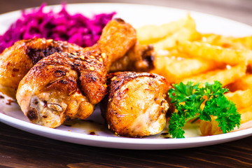 Roast chicken drumsticks with chips and vegetables