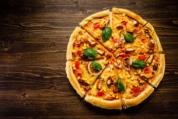 Pizza with chicken and vegetables on wooden background