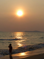 Fototapeta na wymiar kid standing on the beach at sunset
