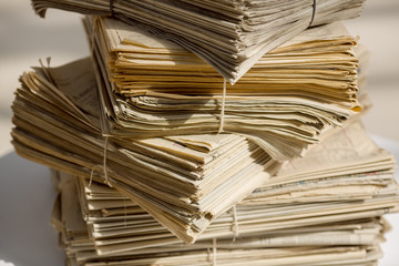 Obraz premium Archive with old newspapers close-up. Pile of unsold newspapers, selective focus.