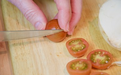 Cutting cherry tomatoes on a table