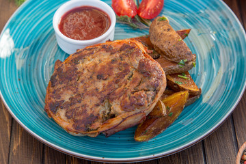 Grilled meat with baked potato and spicy sauce