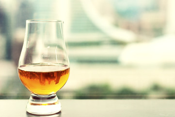 Exclusive Scotch whisky with dollars bank notes next to windows sky view bar, Film tones conception.