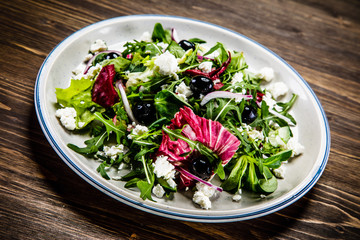 Salad with cottage cheese on wooden background