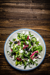 Salad with cottage cheese on wooden background