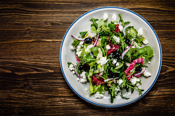 Salad with cottage cheese on wooden background