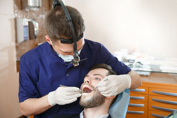 Obraz na płótnie Canvas Doctor dentist treats teeth to the patient.
