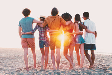 Obraz premium Group of happy friends having fun at ocean beach
