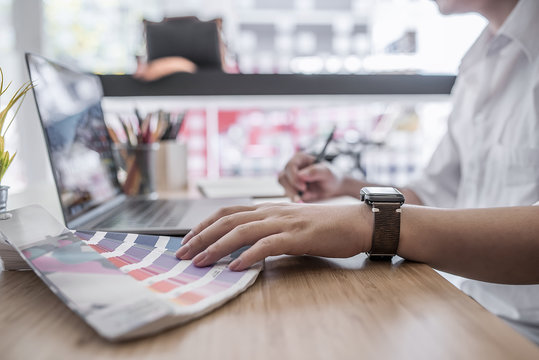 designer pointing on color shade swatch and choosing color for new project